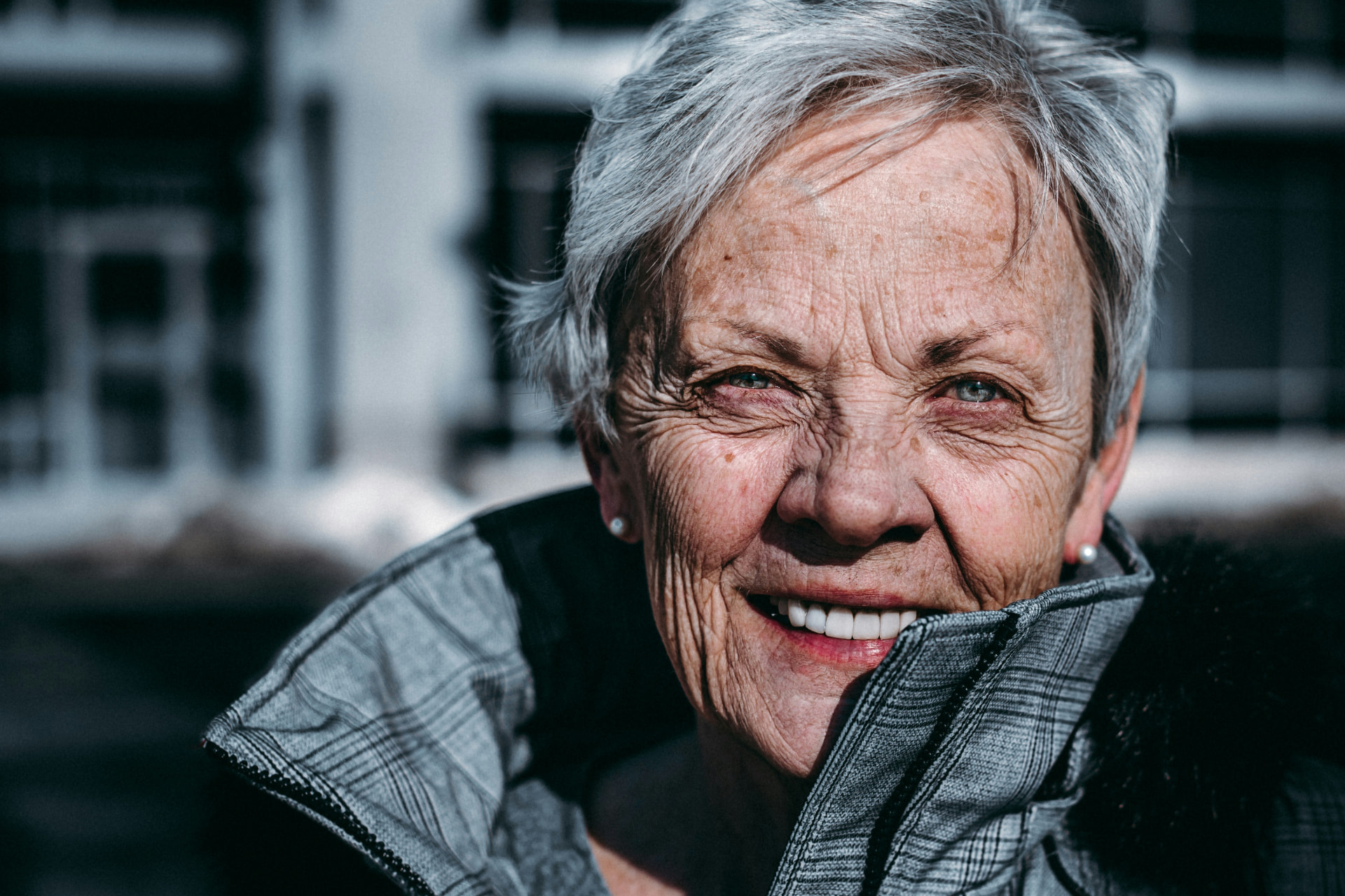 Smiling senior woman outdoors with a full, healthy set of teeth